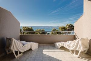 a balcony with chairs and a view of the ocean at Rogač Rooms & Restaurant in Omiš