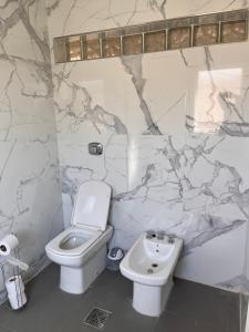 un baño con inodoro y lavabo en Exclusiva Casa Sawa, en Barraquero 26 fotos más
