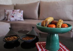 uma tigela verde de fruta numa mesa com um sofá em appartement confort calme propre em Marrakech