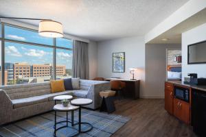 a living room with a couch and a large window at Renaissance Dallas Richardson Hotel in Richardson