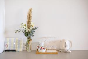 a table with a vase of flowers and a coffee maker at Rogač Rooms & Restaurant in Omiš