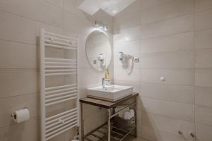 a white bathroom with a sink and a mirror at Rogač Rooms & Restaurant in Omiš +20 photos