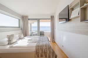 a bedroom with a bed and a large window at Rogač Rooms & Restaurant in Omiš