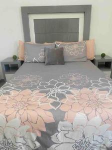 1 cama grande con edredón gris y rosa en Hermosa y Confortable, Petfriendly ¡Facturamos!, en Durango