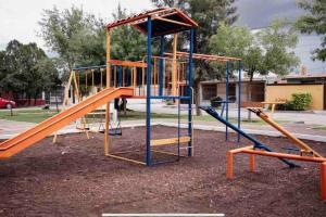 een lege speeltuin met een oranje en blauwe glijbaan bij Hermosa y Confortable, Petfriendly ¡Facturamos! in Durango