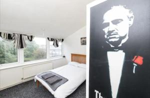 a bedroom with a bed and a poster of a man at Local luxury apartments in London