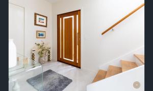 einen Flur mit Holztür und Treppe mit Teppich in der Unterkunft Salt Zen Holiday Townhouse in Agnes Water + 9 Fotos