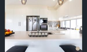 eine Küche mit einem Kühlschrank und einer Schale mit Obst auf der Theke in der Unterkunft Salt Zen Holiday Townhouse in Agnes Water