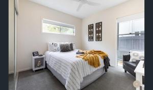 ein weißes Schlafzimmer mit einem Bett und einem Fenster in der Unterkunft Salt Zen Holiday Townhouse in Agnes Water
