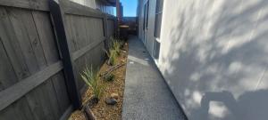 einen Seitengang neben einem Zaun mit Pflanzen in der Unterkunft Salt Zen Holiday Townhouse in Agnes Water