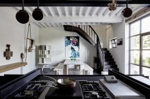 a kitchen with a stove and a staircase at Chateau De La Resle - Design Hotels in Montigny-la-Resle