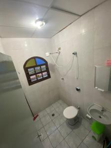a bathroom with a shower and a toilet and a sink at Casa na praia, 15 min de caminhada in Itanhaém