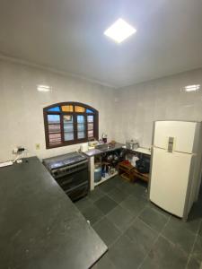 a kitchen with a refrigerator and a counter top at Casa na praia, 15 min de caminhada in Itanhaém