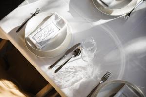 a white table with plates and silverware on it at Rogač Rooms & Restaurant in Omiš