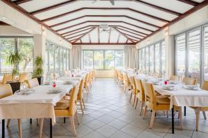 a row of tables in a room with windows at Rogač Rooms & Restaurant in Omiš