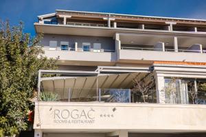 a building with a sign for a hotel at Rogač Rooms & Restaurant in Omiš