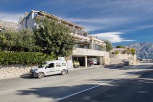 a white car parked in front of a building at Rogač Rooms & Restaurant in Omiš