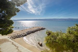 a beach with a rock wall in the water at Rogač Rooms & Restaurant in Omiš