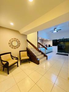 a living room with two chairs and a staircase at Hotel Catalina in Tijuana