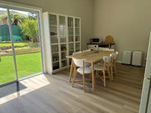 Rodonia - Cottage in Kew في ملبورن: غرفة طعام مع طاولة وكراسي