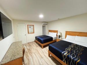 a hotel room with two beds and a table at Hotel Catalina in Tijuana