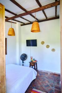 1 dormitorio con 1 cama, 2 lámparas y TV en Hostal Sueño Real Campestre, en San Gil
