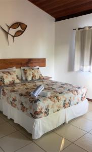 a bedroom with a bed with a book on it at A casa do vizinho in Itaparica