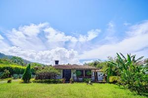a small house in a yard with a green field at Hostal Sueño Real Campestre in San Gil