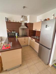 a kitchen with a stainless steel refrigerator and cabinets at Très jolie F2 cosy 45m2 avec balcon et parking proche Paris in Livry-Gargan