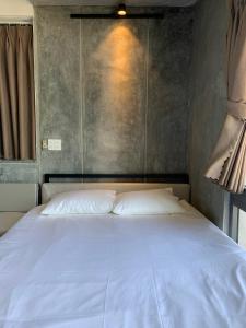 Buôn Mhang的住宿－miniHomestay green view - single room - AC and bathtub - Ea Kar - Dak Lak，卧室内的一张白色床,卧室内有墙壁