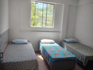 a room with two beds and a window at Pousada Family in Salvador