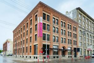 a large brick building with a pink sign on it at New York Style Loft with Parking Exchange District Coffee Gym in Winnipeg