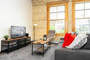 sala de estar con sofá y TV en New York Style Loft with Parking Exchange District Coffee Gym en Winnipeg
