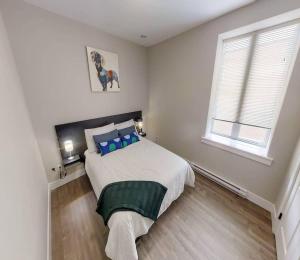 1 dormitorio con 1 cama grande con almohadas azules en Premium Condo Heart of Uptown Location Parking Coffee en Saint John