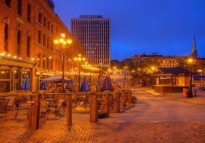 une rue de la ville avec des tables et des parasols la nuit dans l'établissement Pristine Harbour View Towers Exec Suite Coffee Parking, à Saint-Jean