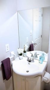 La salle de bains blanche est pourvue d'un lavabo et d'un miroir. dans l'établissement Pristine Harbour View Towers Exec Suite Coffee Parking, à Saint-Jean
