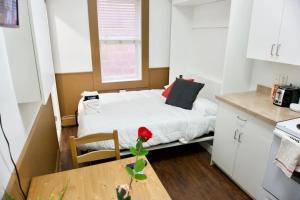 a small room with a bed and a table at Amazing DT Apartment w Parking Location Coffee in Moose Jaw