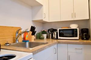 a kitchen with a sink and a microwave at Cozy Studio Perfect for Business Travelers Downtown in Moose Jaw