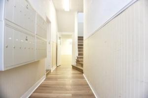 a hallway with white walls and wooden floors at Cozy Studio Perfect for Business Travelers Downtown in Moose Jaw