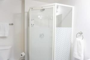 a white bathroom with a shower and a toilet at Cozy Studio In the Heart Uptown Saint John! Parking Coffee in Saint John