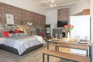 um quarto com uma cama e uma parede de tijolos em Cozy Studio In the Heart Uptown Saint John! Parking Coffee em Saint John