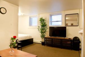 uma sala de estar com uma televisão de ecrã plano e uma cama em Cozy Studio Downtown Parking Coffee Location em Moose Jaw