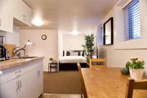 uma cozinha e sala de estar com uma mesa e uma cama em Cozy Studio Downtown Parking Coffee Location em Moose Jaw