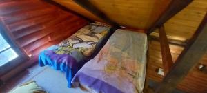 Bett in einem Zimmer in einer Hütte in der Unterkunft Cabaña de Troncos en Colonia Suiza in Mendoza