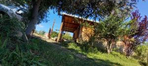 ein altes Haus an der Seite eines Hügels in der Unterkunft Cabaña de Troncos en Colonia Suiza in Mendoza