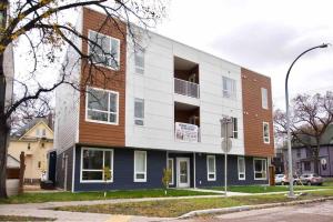 an apartment building with a brown and white at Gorgeous Modern 2BD Condo Heart of Wpg Coffee Location in Winnipeg