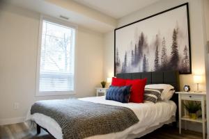 - une chambre avec un lit doté d'oreillers rouges et bleus dans l'établissement Premium Modern Condo Top Location 2Bed, à Winnipeg