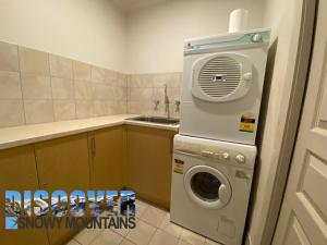 a kitchen with a washing machine and a sink at Tomarlin Views 1 in Thredbo