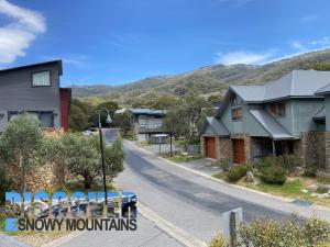 a street with houses and mountains in the background at Tomarlin Views 1 in Thredbo
