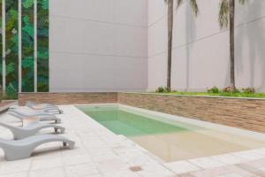 una piscina en un edificio con una fila de sillas en Virrey Congreso- Deluxe 2 Ambientes en Buenos Aires